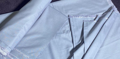 Light blue fabric with a visible seam on a dark surface